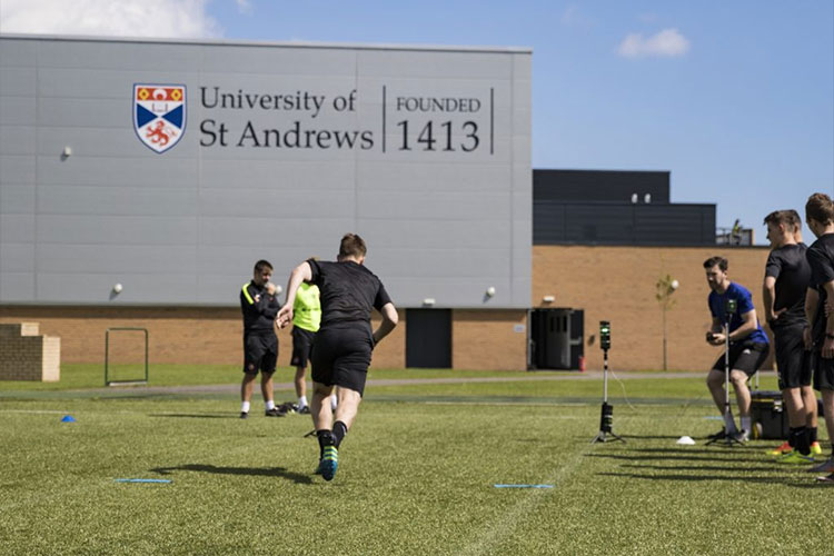 Man running on the grass outside the sports centre in St Andrews