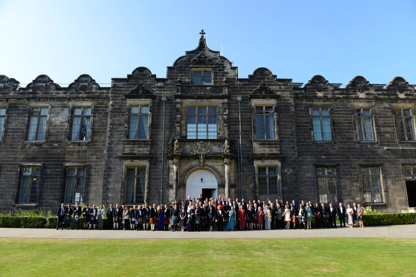 Full wedding party outside entrance to Lower College Hall