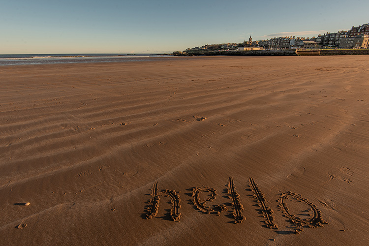 beach with the words extra written in sand
