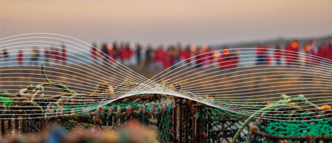 Students walking on the cross pier with fishing nets and lobster pots in the foreground