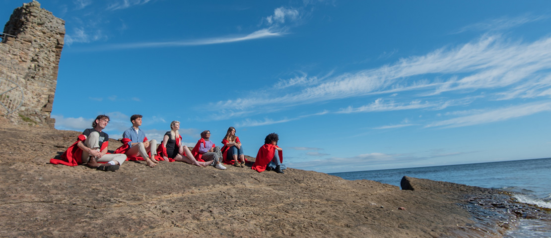 students sitting on rocks