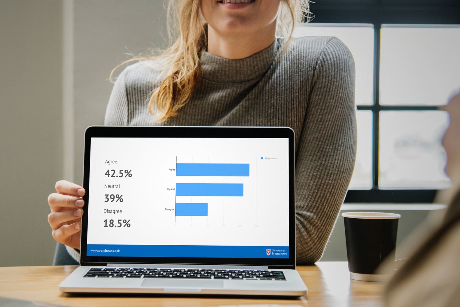 Young woman showing St Andrews presentation on laptop screen