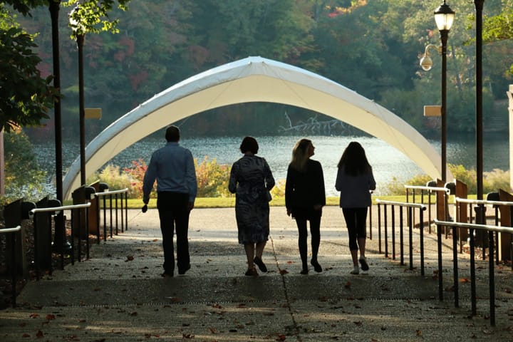Four people walking on campus