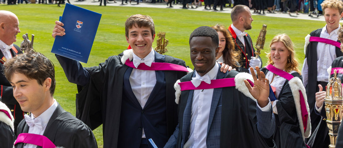 Two graduants waving