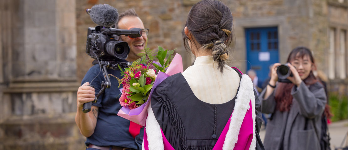 A graduant being photographed and filmed in St Salvator's Quad