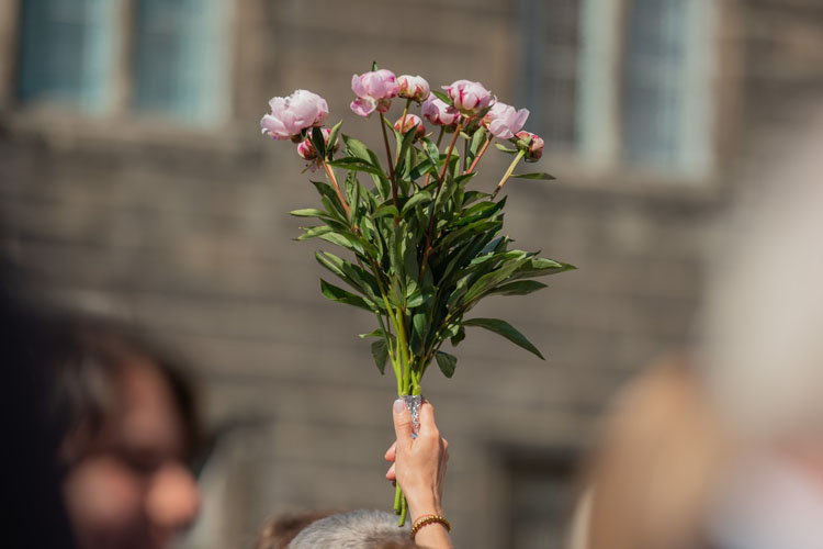 A close up of a bunch of flowers being held up in the air