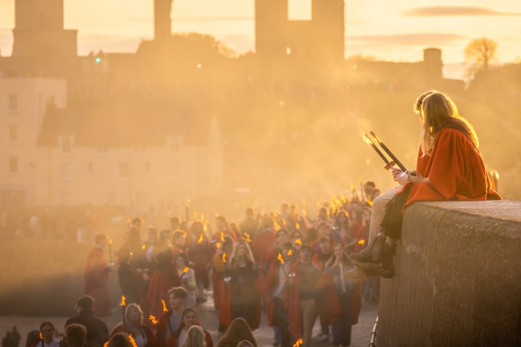 Students sitting on the pier during golden hour at the Gaudie pier walk in St Andrews.
