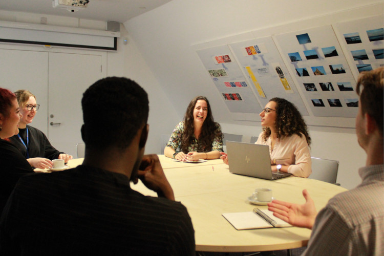 University staff working as a team around a table in the Learning Loft