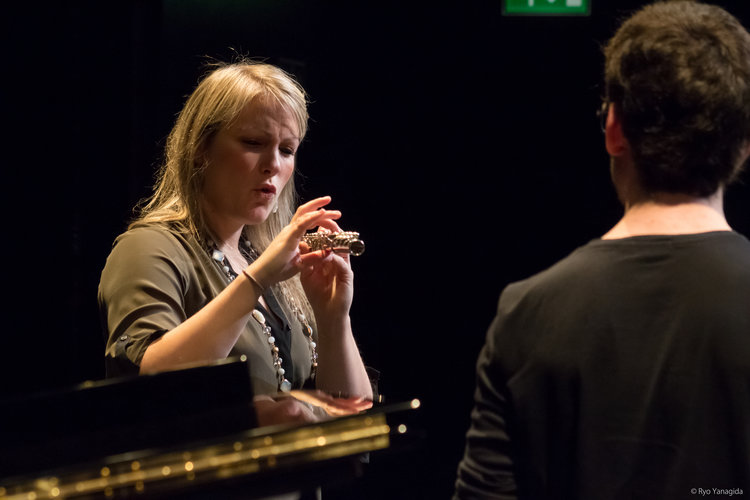 Teacher demonstrating playing the flute