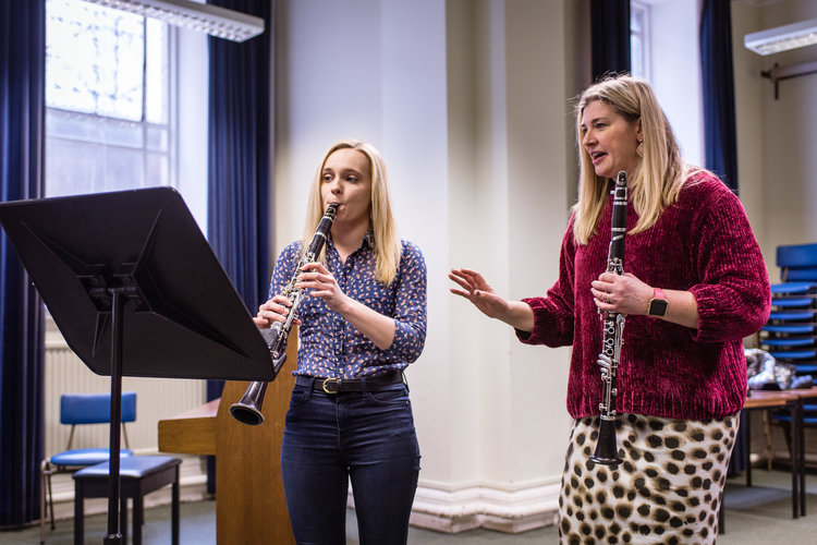 A teacher and student playing the clarinet