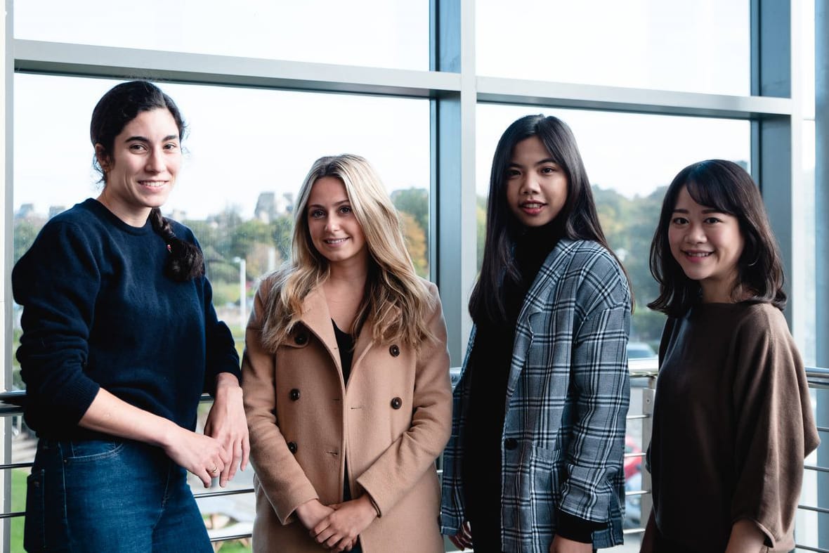 Four students posing in Gateway stairwell