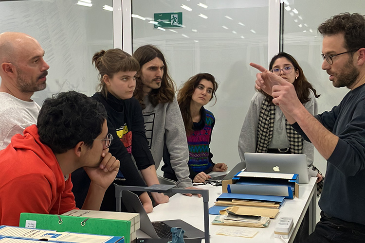 Students and instructor gathered by a table containing archival materials