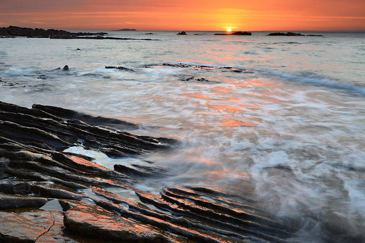 A foaming sea at sunset
