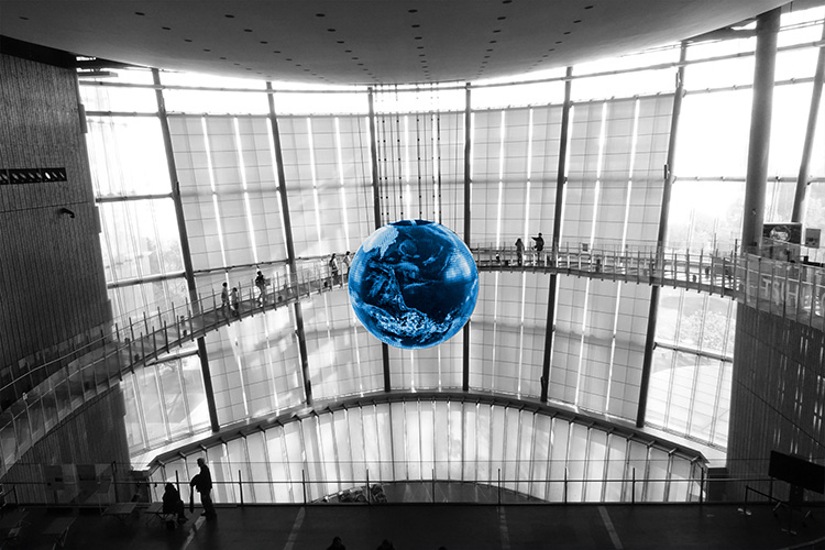 A blue globe hanging inside a glass building