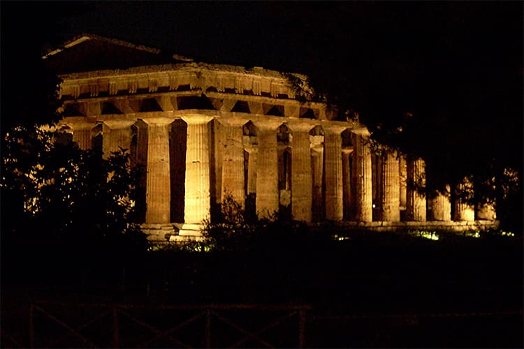 ancient greek ruins with columns floodlit at night