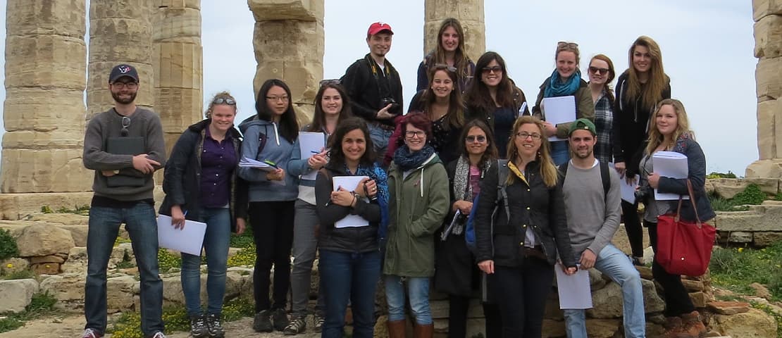 Students and Prof Sweetman standing in ancient ruins