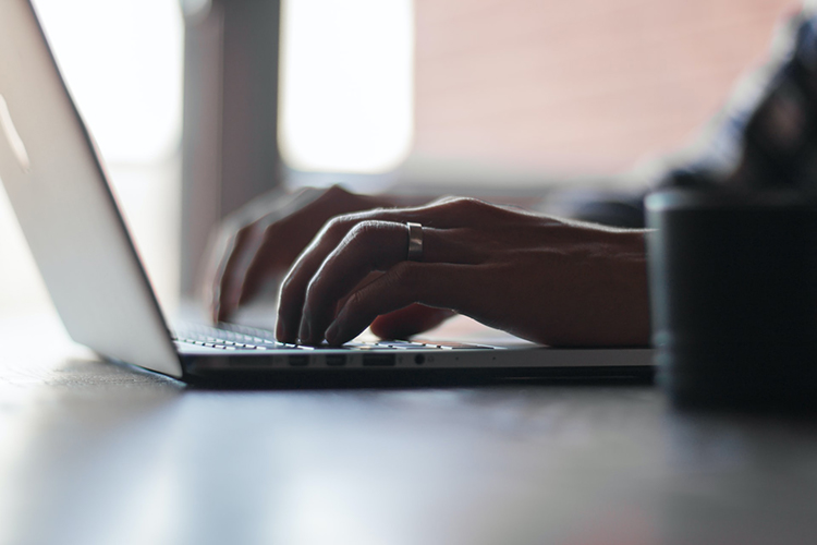 hands poised over laptop keyboard
