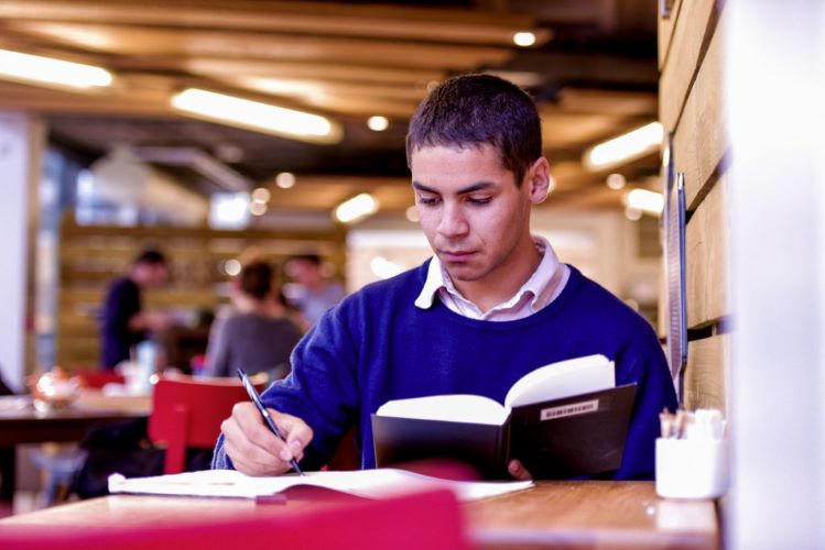 St Andrews student reading inside Rectors cafe, University of St Andrews