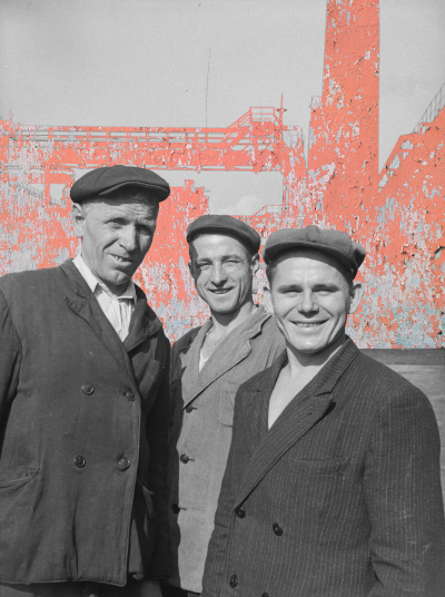 Composite photo - Miners against backdrop of mining structure