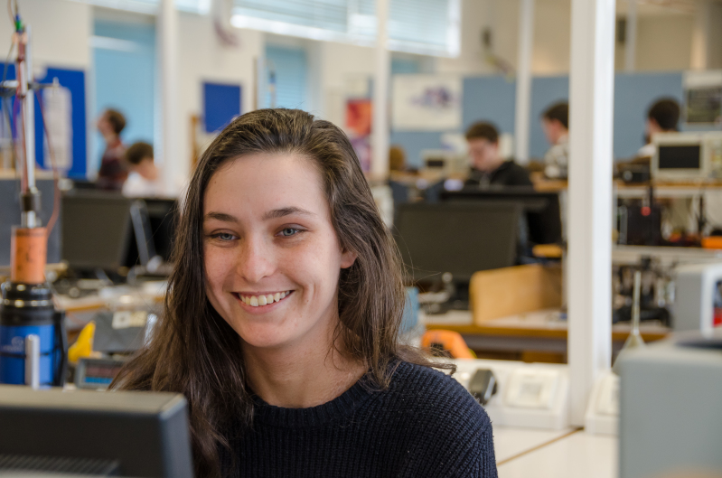 Smiling female student in Physics teaching lab.