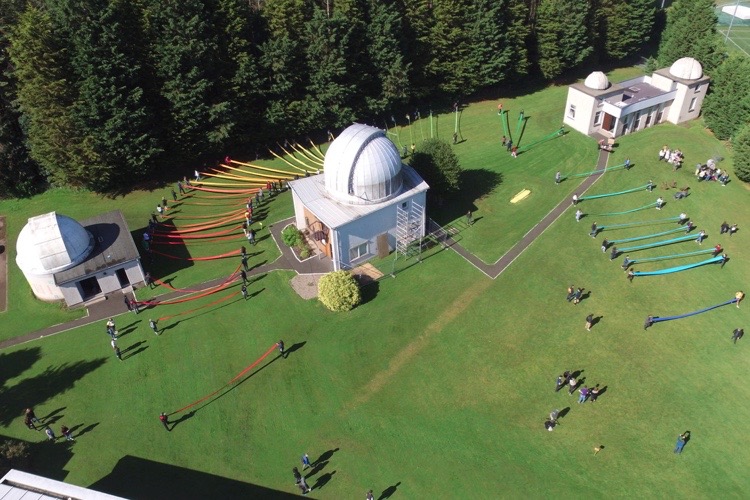 Students unfurl colourful ribbon to create a spectrum on the Observatory lawn.