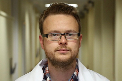Alex Ward in a lab coat.