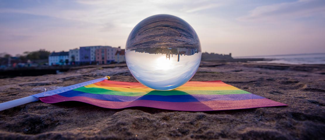 Crystal ball reflecting St Andrews harbour and LGBT flag