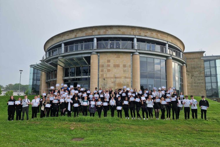 A group of First Chances Fife students at their graduation ceremony in front of the Gateway building at the University of St Andrews.