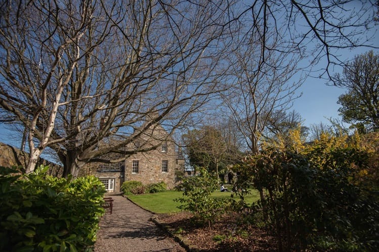 Exterior of old University building with trees and shrubs