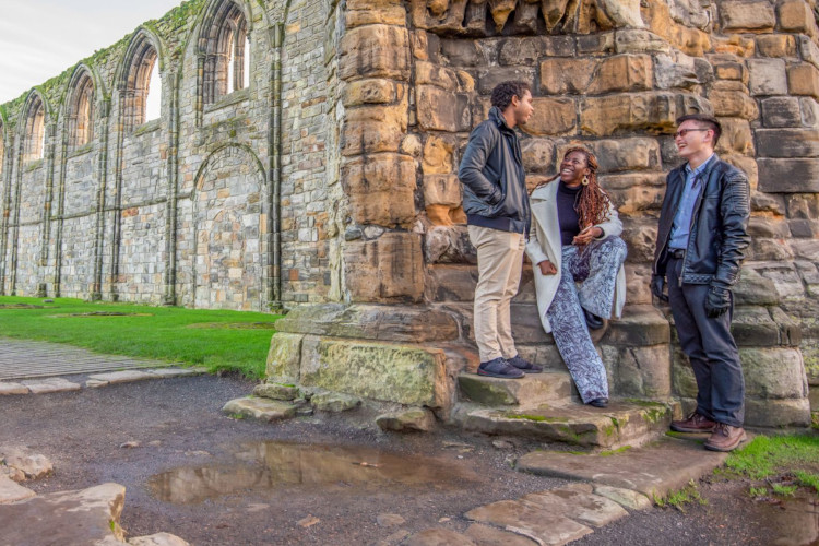 Three postgraduate students by St Andrews cathedral