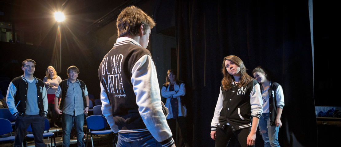 A group of students performing a play on stage