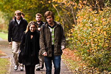 Students walking down an autumnal path