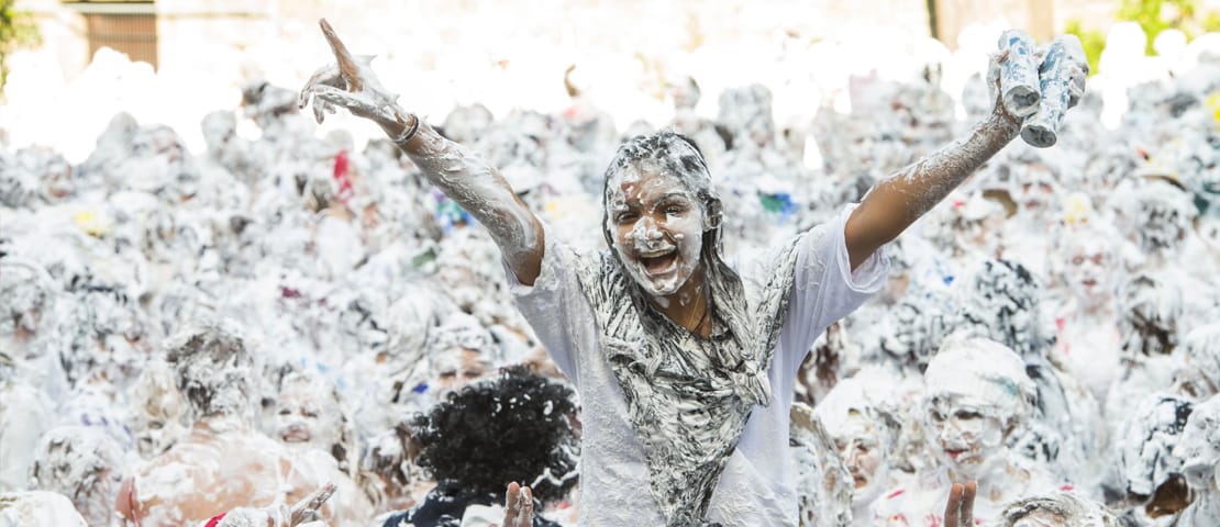 Girl on someones shoulders during the raisin monday foam fight