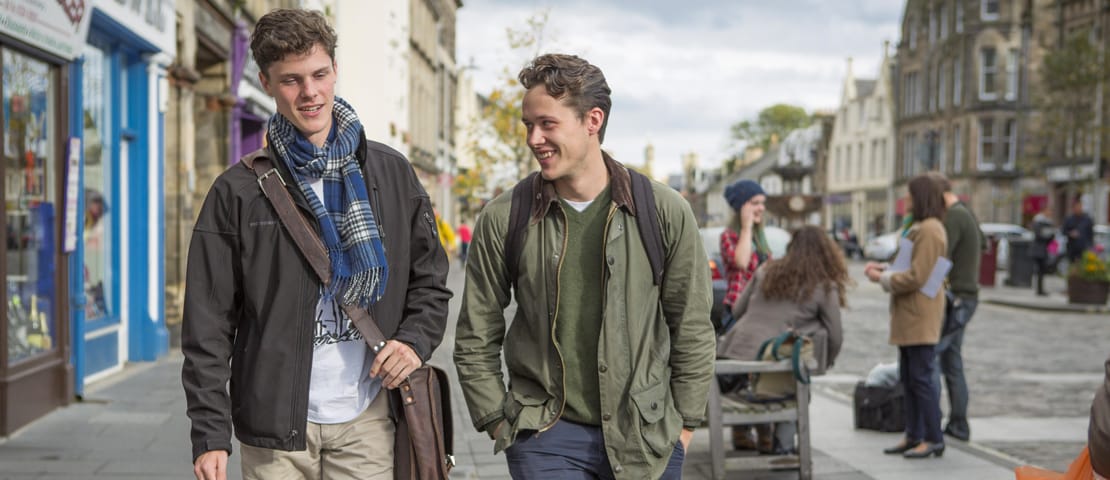 Two young men walking through St Andrews